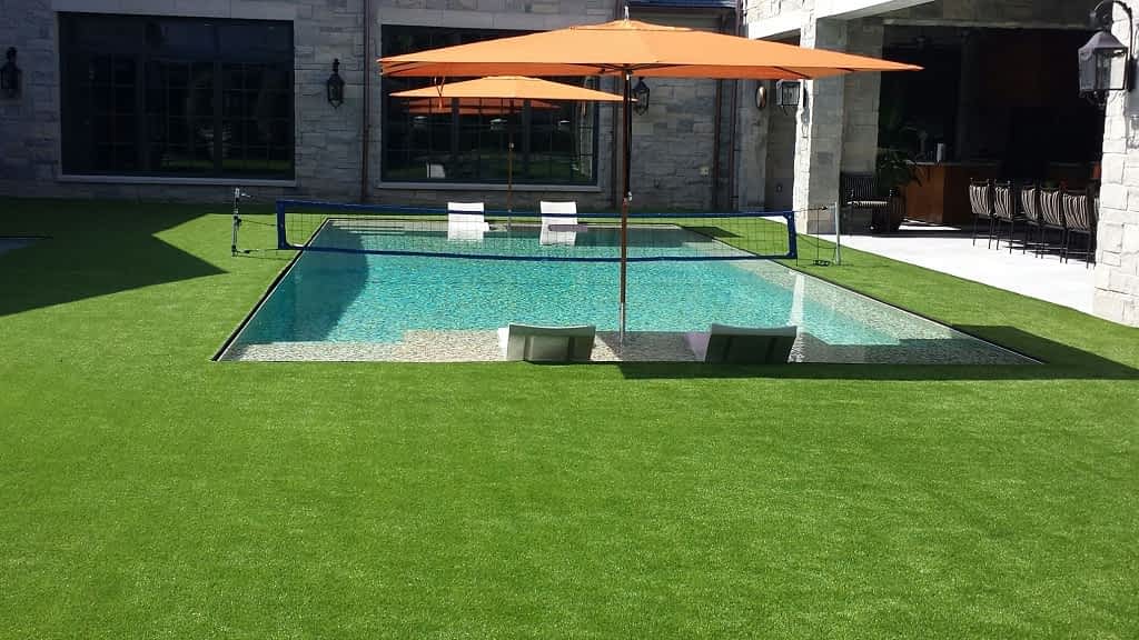Quais são as vantagens de usar grama sintética ao redor da piscina em sua casa?